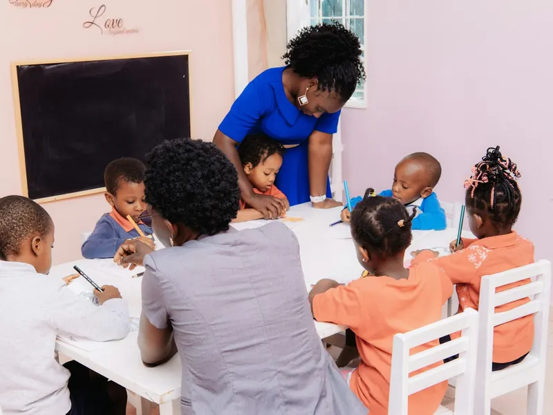 Maestra guiando a niños de preescolar mientras dibujan