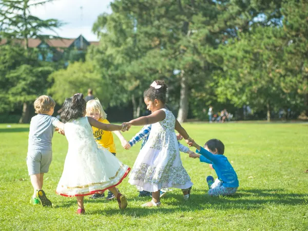 Niños tomados de la mano jugando en círculo